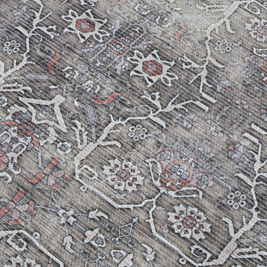 Close-up of a patterned rug with intricate designs on a gray background