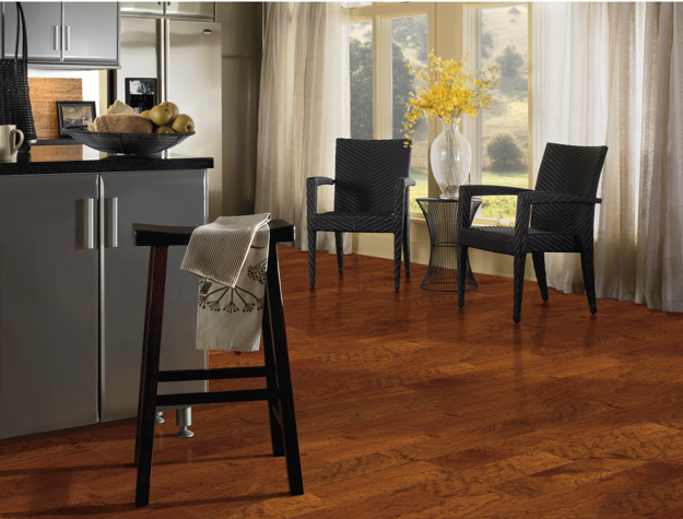 Modern kitchen with wooden flooring, black chairs, and a window with curtains.