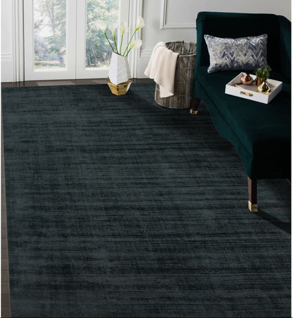 Dark gray rug in a living room with a green armchair and decorative items.