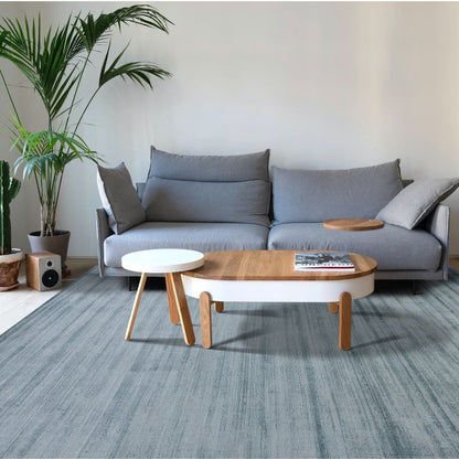 Modern living room with a gray sofa, wooden coffee table, and plants.