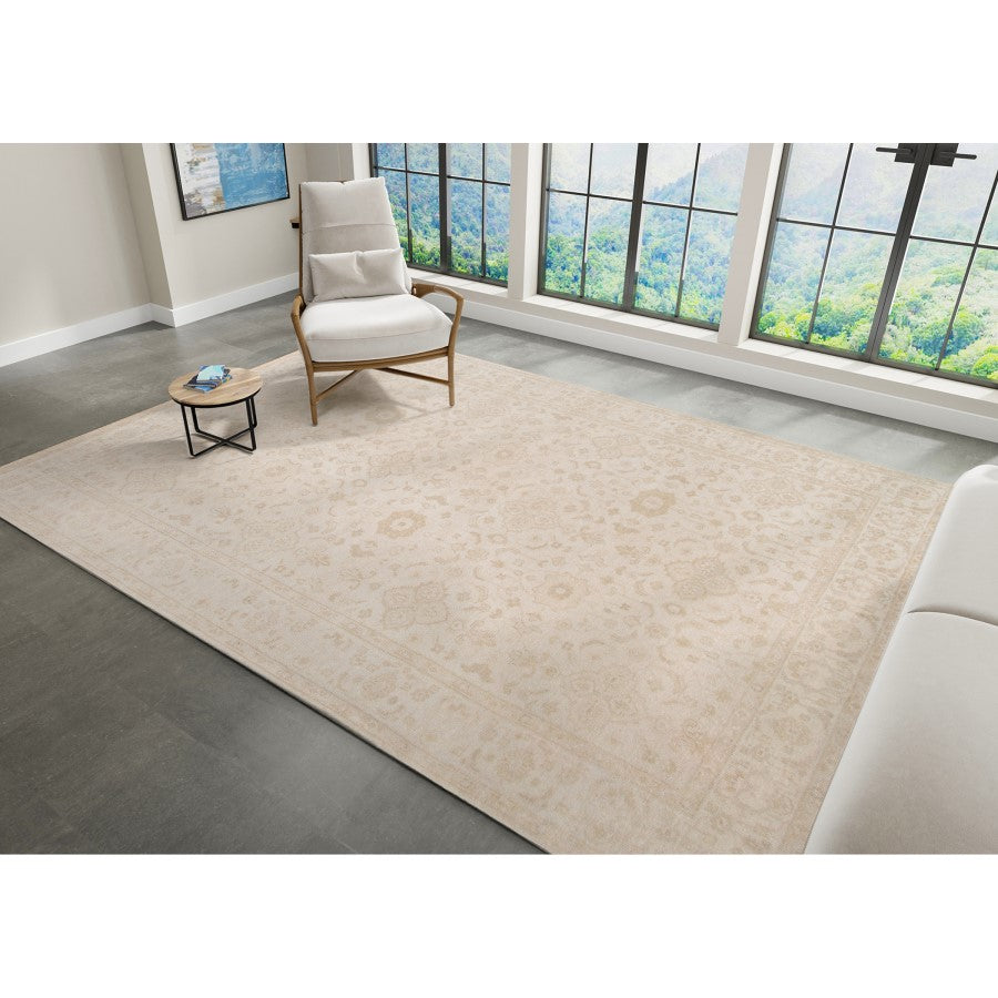 Beige rug in a room with a chair and coffee table near large windows.