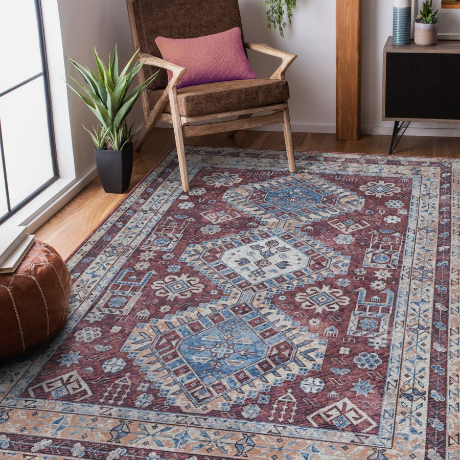 Decorative rug with intricate patterns in a room with a chair and plants.