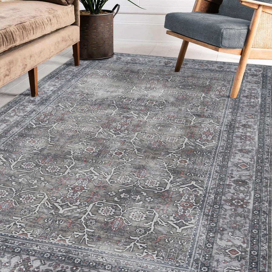 Patterned gray rug in a room with furniture and decor.