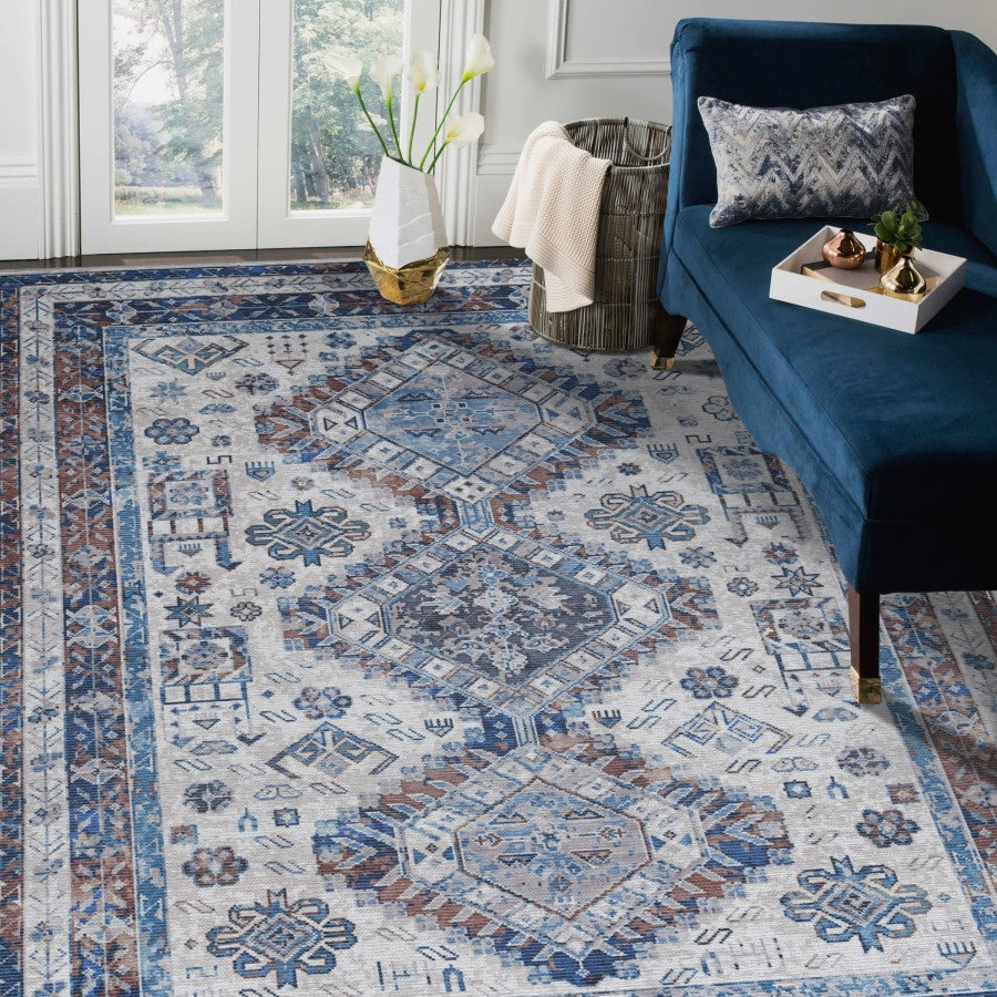 Patterned rug in a living room with a blue sofa and decorative items.