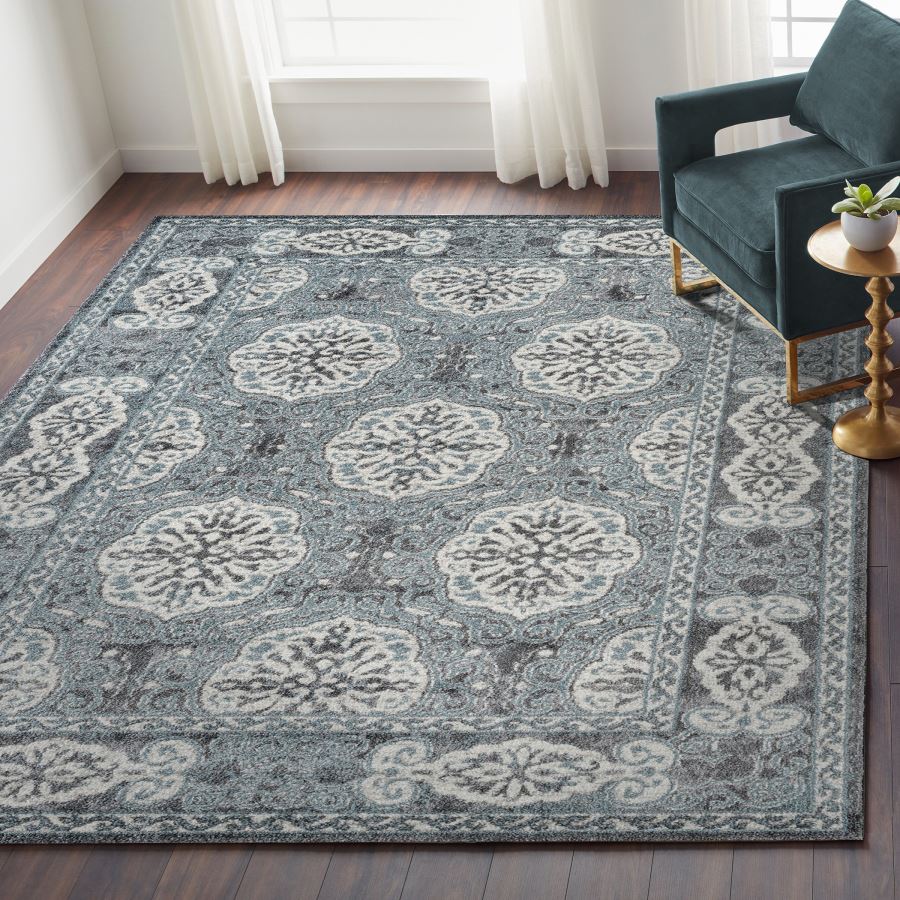 Decorative rug with a floral pattern in a room with a sofa and side table.