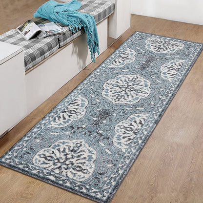 Long blue patterned rug on a wooden floor with a bench and blue blanket in the background.