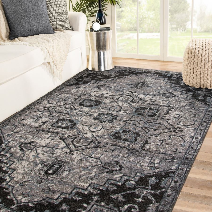 Decorative black and gray area rug in a living room setting with a couch and coffee table.