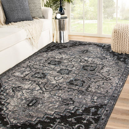 Decorative black and gray area rug in a living room setting with a couch and coffee table.