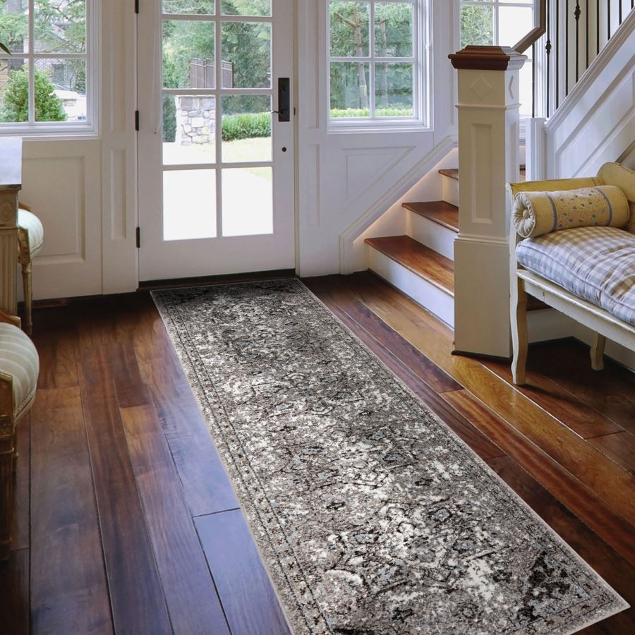 Long rectangular rug on a wooden floor in a home setting with a staircase and doors.