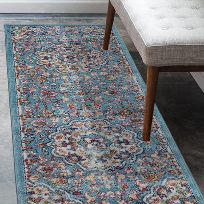 Decorative rug with floral pattern on a floor next to a chair.