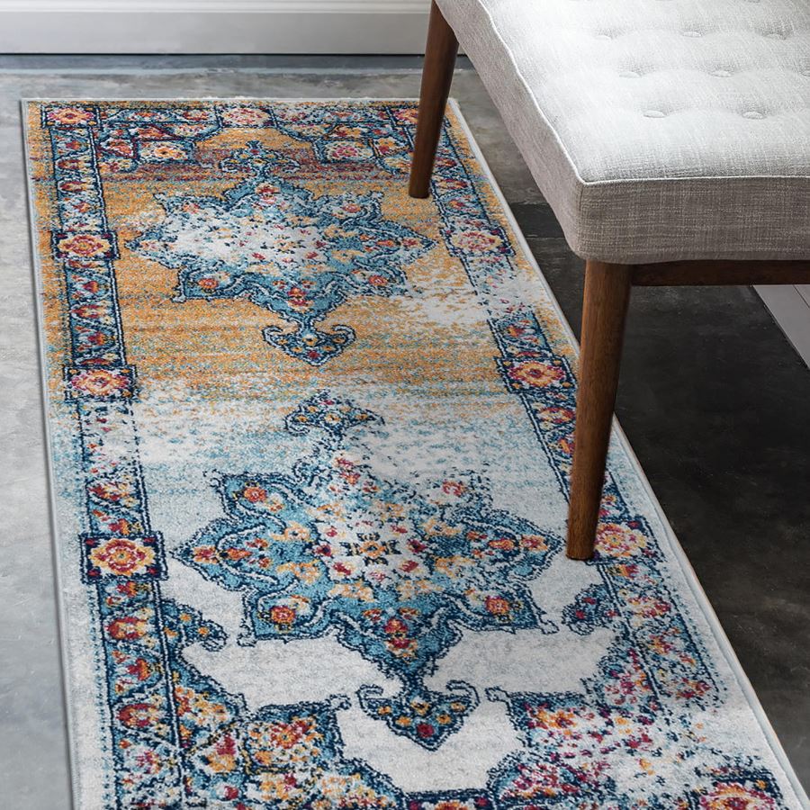 Decorative rug with intricate patterns on a floor next to a chair.