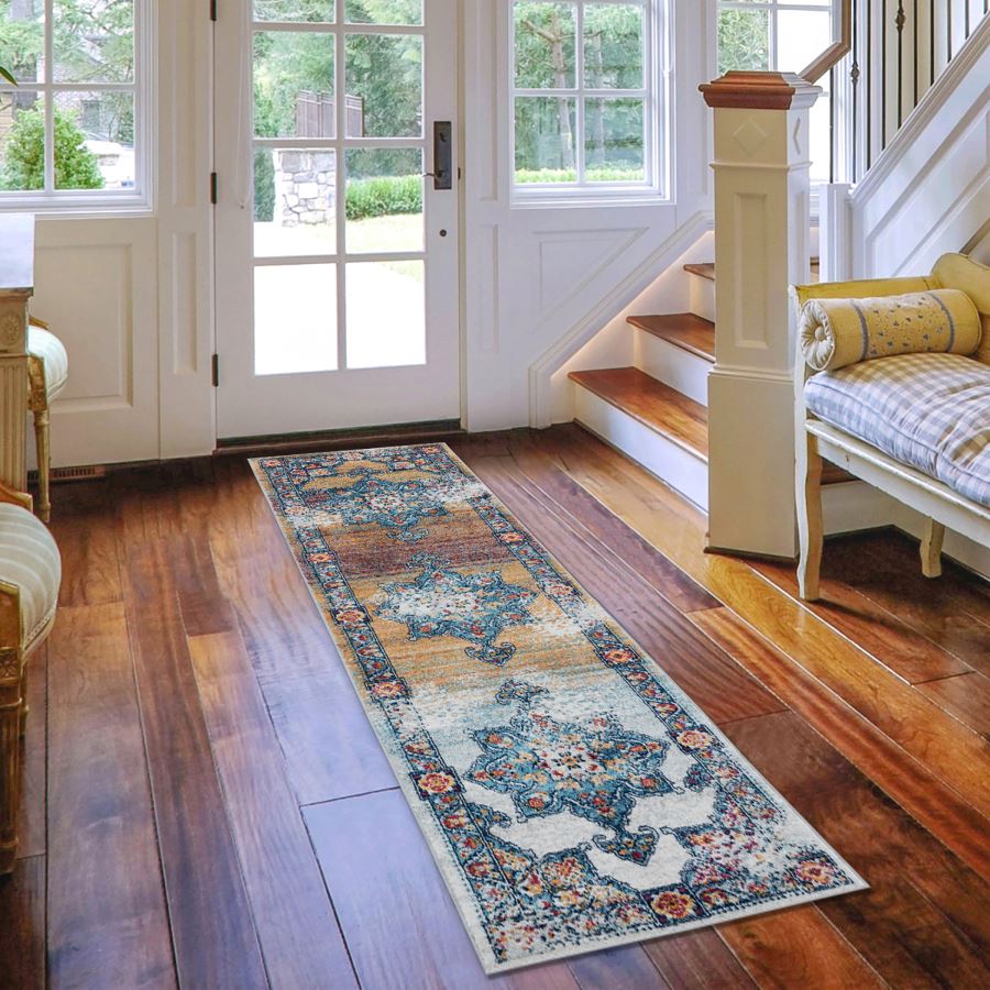 Decorative rug on a wooden floor in a home interior with a staircase and doors.