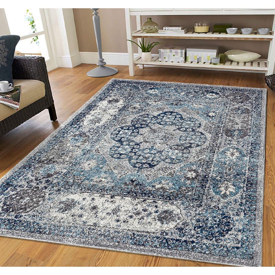 Blue and white patterned rug on a wooden floor in a living room setting.