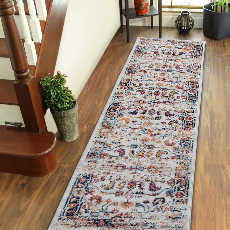 Decorative runner rug on a wooden floor next to a staircase