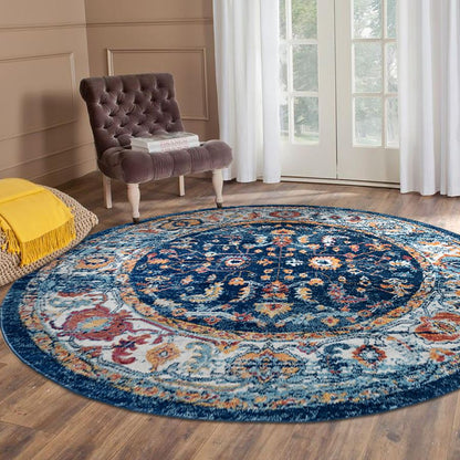 Round patterned rug on a wooden floor with a chair and yellow blanket in the background.