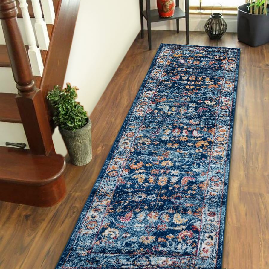 Blue floral patterned rug on a wooden floor next to a staircase