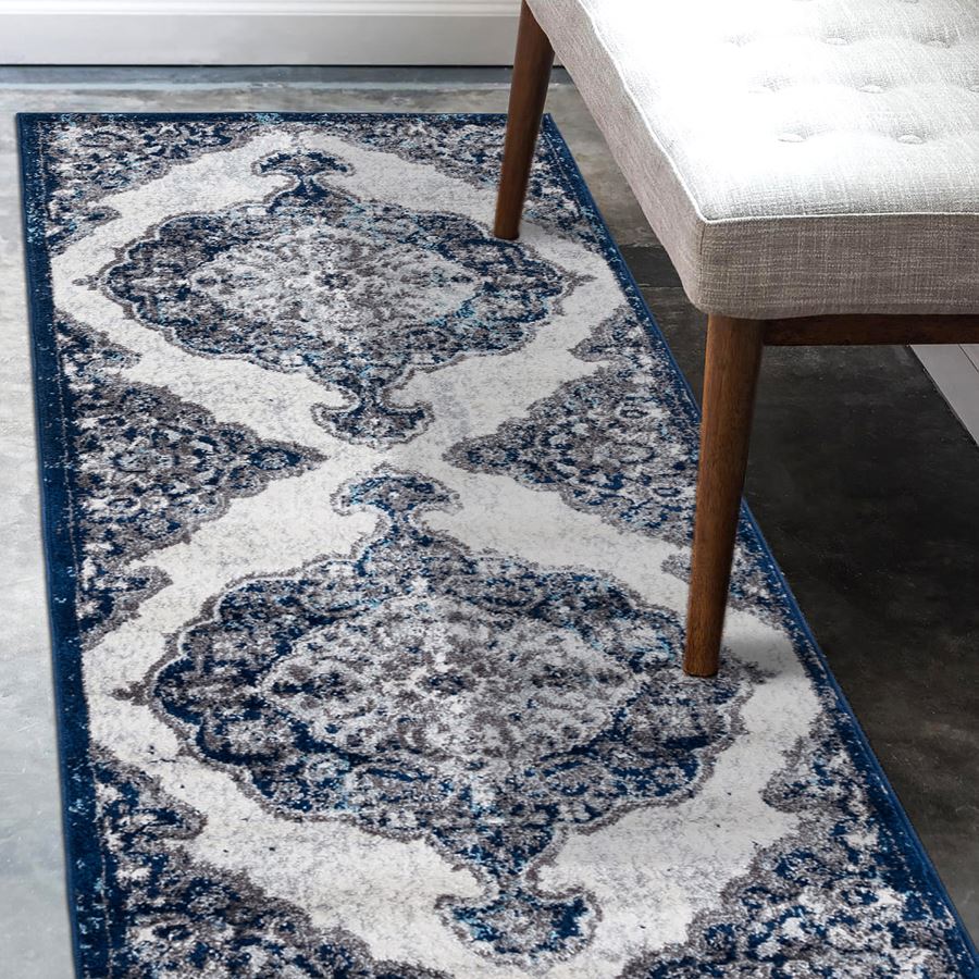Decorative blue and white patterned rug on a floor with a chair partially visible.