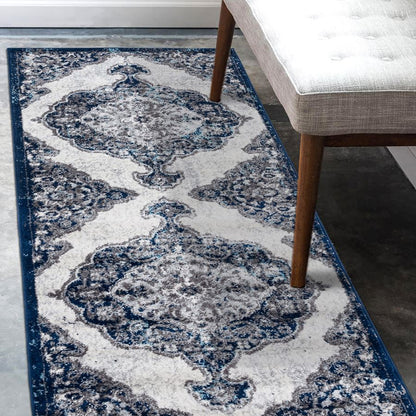 Decorative blue and white patterned rug on a floor with a chair partially visible.