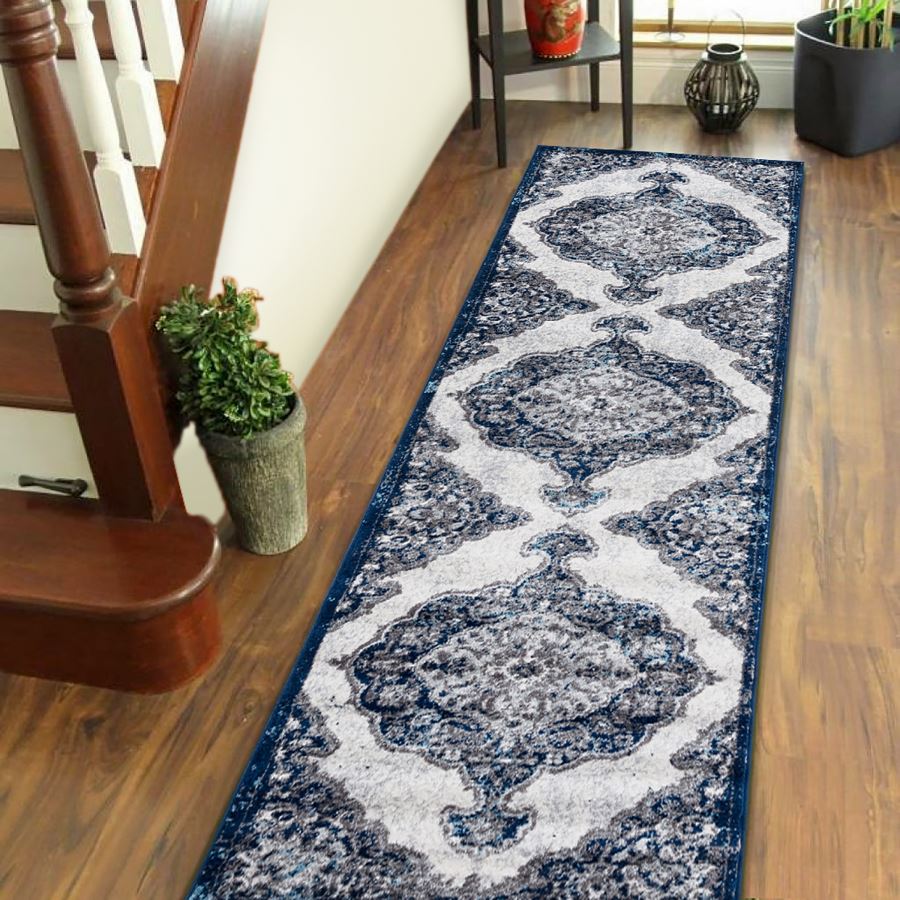 Blue and white patterned rug on a wooden floor next to a staircase