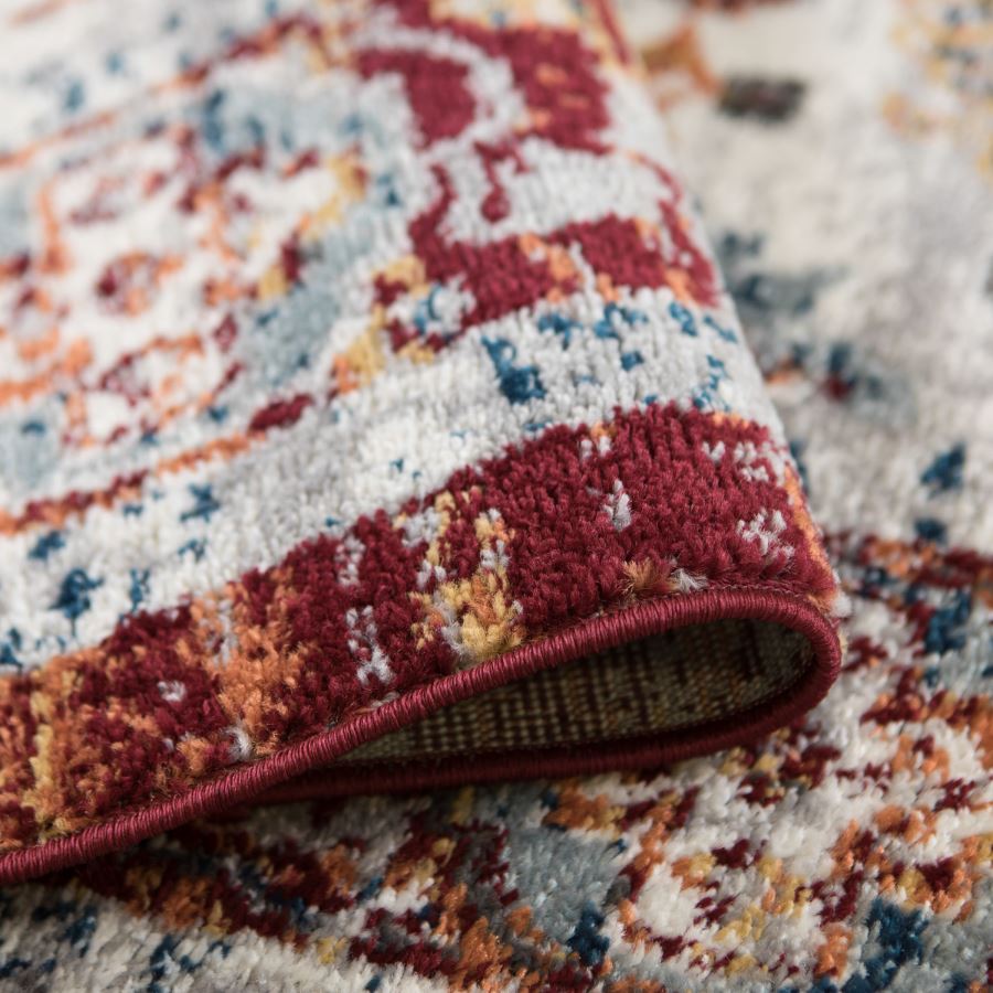 Close-up of a patterned rug with red, blue, and beige colors.