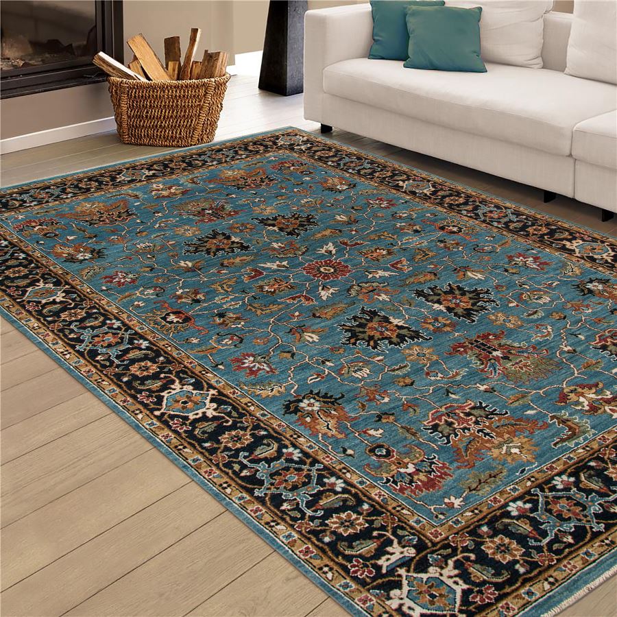 Decorative rug with floral pattern on a wooden floor in a living room setting.
