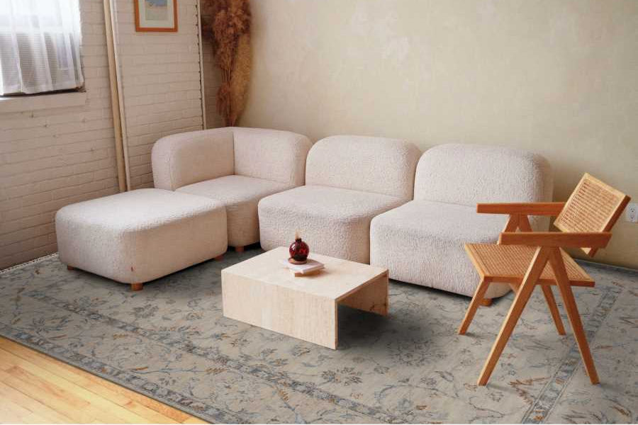 Beige sectional sofa with a wooden coffee table and chair in a living room setting.