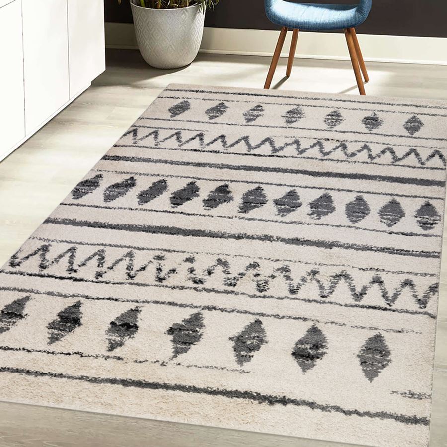 Patterned rug on a wooden floor with a chair and plant in the background