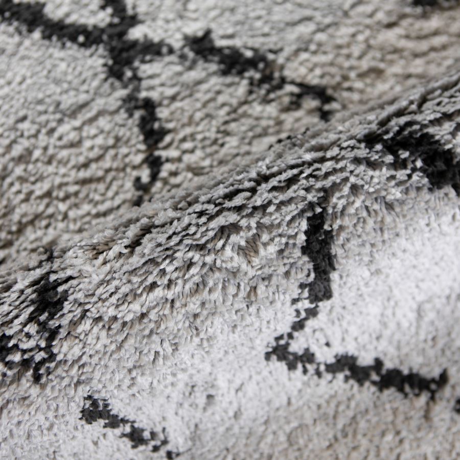Close-up of a textured gray and black rug with geometric pattern