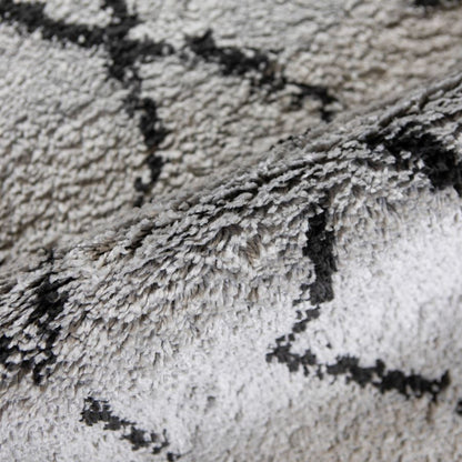 Close-up of a textured gray and black rug with geometric pattern