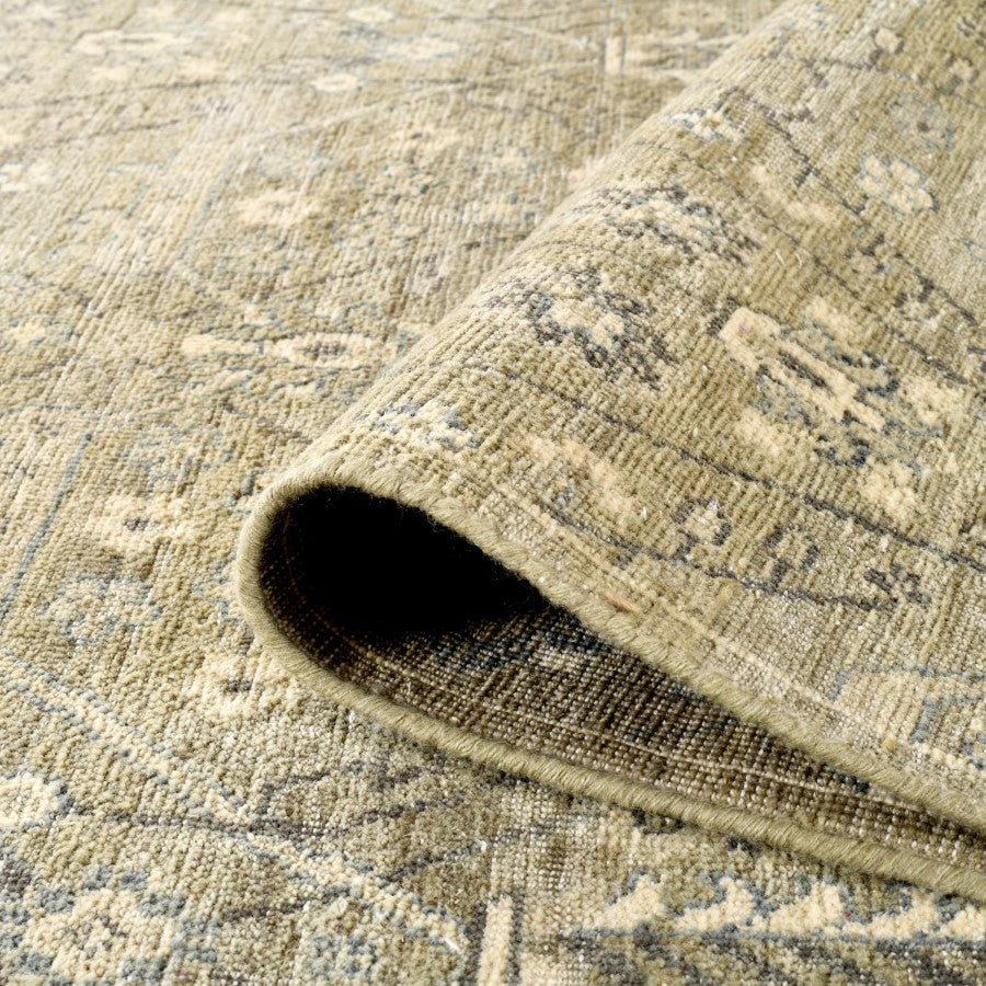 Close-up of a textured beige rug with a rolled edge.
