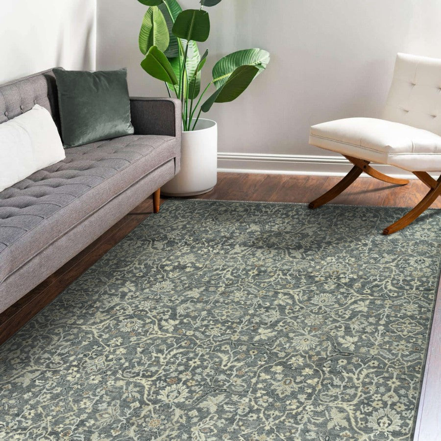 Living room with a patterned rug, gray sofa, and white chair.