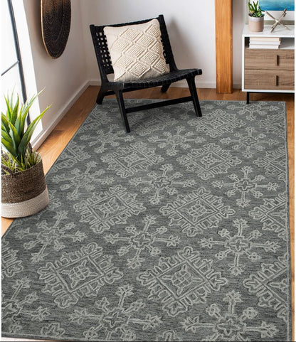 Gray patterned rug in a room with a chair and plant