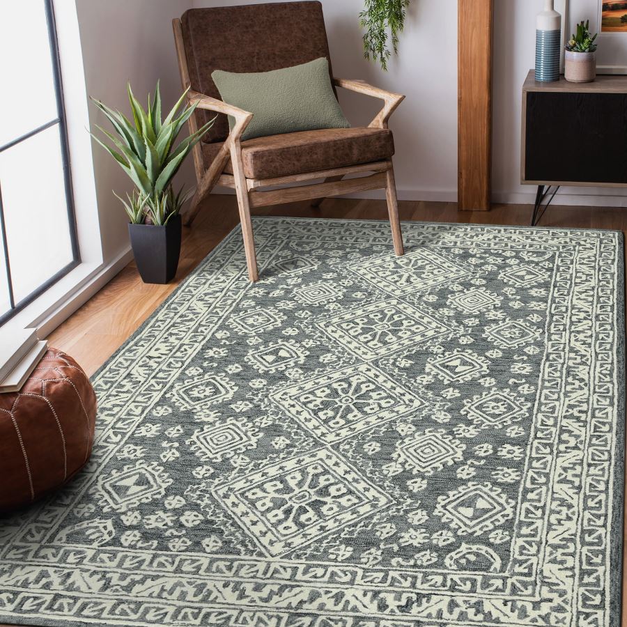 Patterned rug on a wooden floor with a chair and plants in a room.