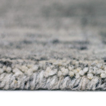 Close-up of a textured gray and white rug with a blurred background