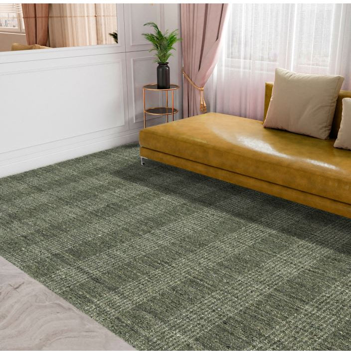 Brown sofa with beige cushions on a green checkered rug in a room with white walls and pink curtains.