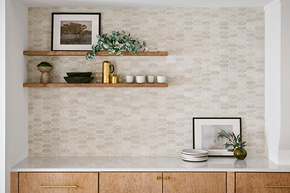 Modern kitchen with wooden shelves, decorative items, and a tiled backsplash.