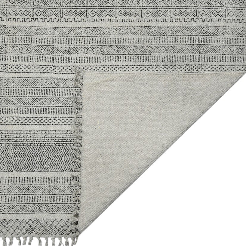 Gray and white patterned fabric with fringes on a white background