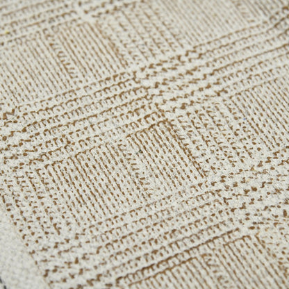 Close-up of a textured beige fabric with a diamond pattern