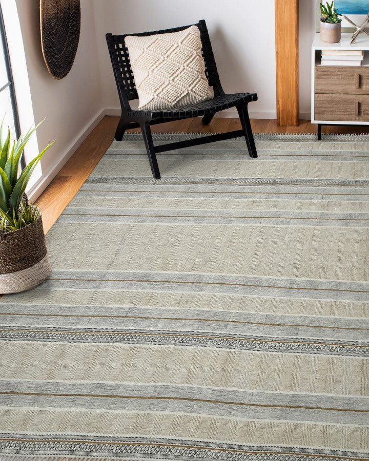Striped area rug in a room with a chair and plant