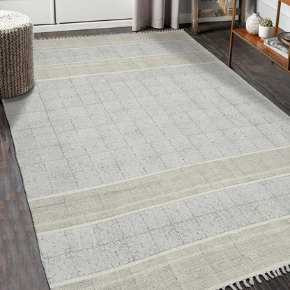 Gray and beige checkered area rug in a room with wooden flooring and furniture.