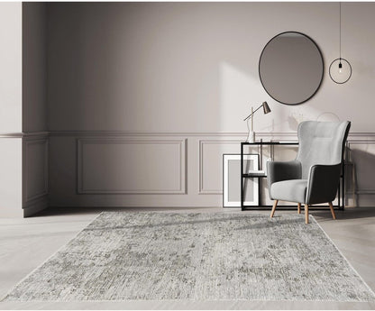 Modern interior with a gray armchair, round mirror, and textured rug.