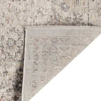 Close-up of a textured rug corner with a neutral color palette.