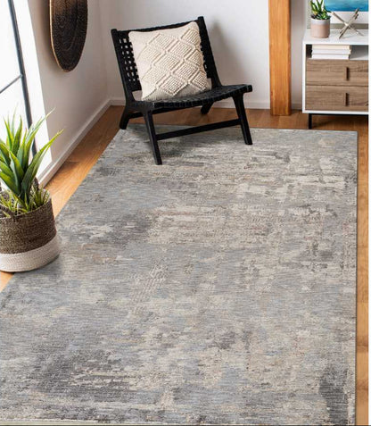 Gray area rug in a room with a chair and plant