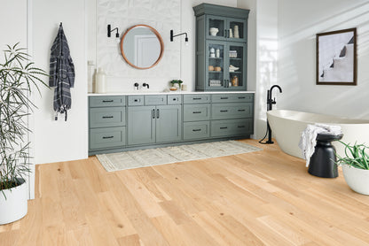 Modern bathroom with gray cabinets, freestanding bathtub, and wooden floor.