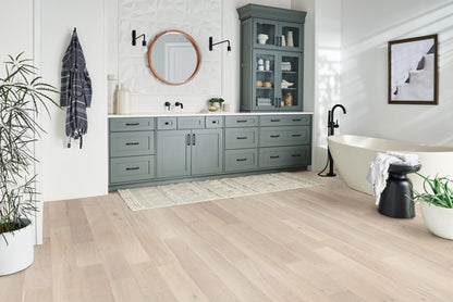 Modern bathroom with gray cabinets, freestanding bathtub, and decorative elements.