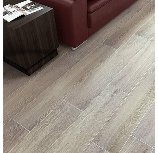 Wooden floor tiles in a room with a dark wooden side table and red sofa.