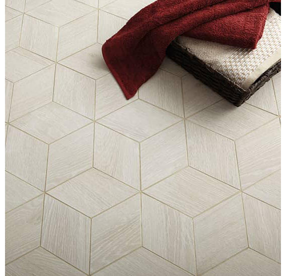 Hexagonal tiles on a floor with a red towel and brown rug.