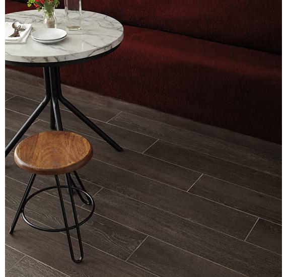 Dark wood flooring with a marble table and wooden stool in the foreground.