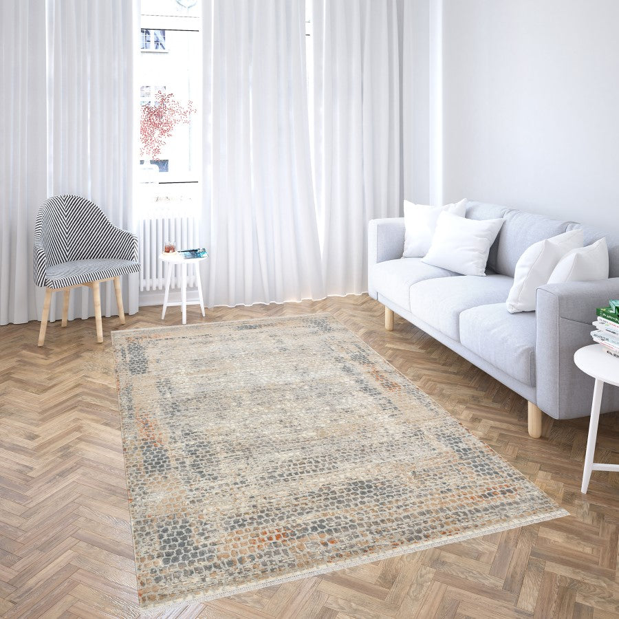 Living room with a patterned rug, gray sofa, and wooden floor.