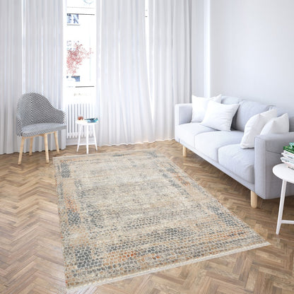 Living room with a patterned rug, gray sofa, and wooden floor.